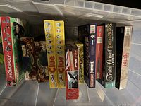 Overview of board games inside clear storage bin