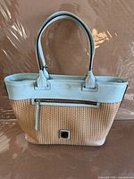 Full view of blue leather and tan woven Dooney & Bourke handbag front