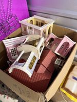 Box containing various Calico Critters dollhouse pieces