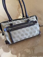 Full view of front and handles showing monogram canvas and leather trim