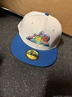 Front view of off-white and blue New Era Rockies fitted cap showing mountain logo and size sticker