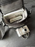 Open camera bag showing manuals and camera