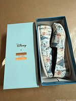 Shoes in box with lid showing Disney x TOMS branding