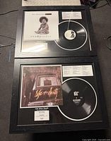 Both framed vinyl record displays stacked vertically showing album art and records