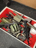 Top view of assorted plastic GI Joe weapons and accessories in box
