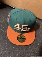 Front view of green Houston Astros fitted cap with orange brim and .45s embroidery, size sticker visible