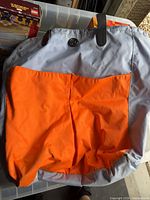 Front of tote showing orange panel, grey upper section, Lululemon logo, strap attachment