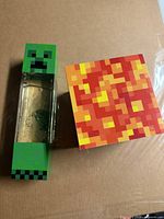 Creeper glitter lamp and magma cube light on cardboard surface