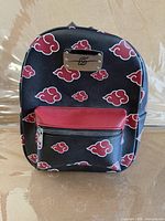 Front view showing Akatsuki cloud pattern, metal emblem, red front pocket