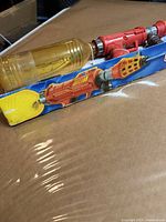 Water gun partially removed from box showing reservoir and body