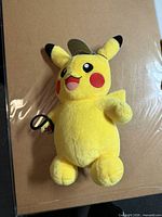 Front view of Detective Pikachu Build-A-Bear plush with hat and magnifying glass