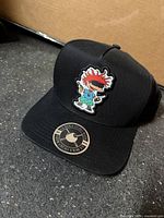 Front view of black Rugrats snapback hat with Chuckie Finster patch and brim sticker