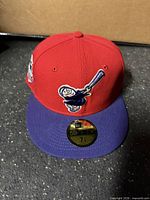 Front view of red and purple Padres fitted hat with Swinging Friar logo and sticker