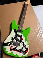 Front view showing Joker graphic, pickups, controls, tremolo bridge