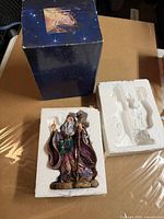 Wizard figurine with Styrofoam insert beside original celestial themed box