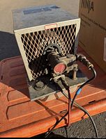 Front view showing ventilated grille and pump assembly with hose fittings