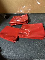Three red YSL cosmetic bags on surface