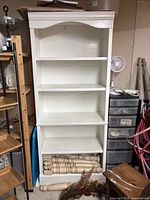 Front view of one bookshelf showing five shelves and crown molding