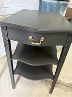 Full view of side table showing drawer, shelves, brass pull