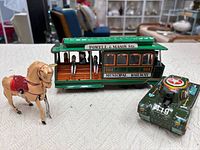 All three tin toys together: cable car, horse, tank