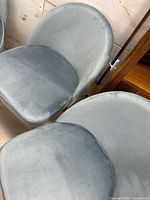 Two blue velvet dining chairs showing seat and upholstery texture