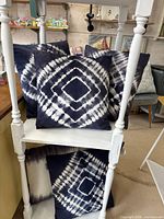 Group of tie-dye pillows displayed on shelving