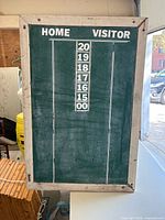 Front view of green chalk dart scoreboard with Home-Visitor headings and number tiles