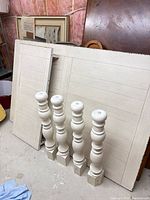 disassembled off-white plank-style tabletop panels and four turned legs