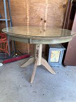 Full view of round pedestal table with glass top