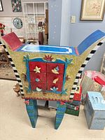 Front view of colorful hand-painted cabinet with six drawers and decorative legs