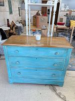 Front view of dresser showing three drawers, knobs, keyholes, glazed finish