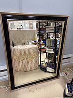 Front view of rectangular black and gold framed mirror