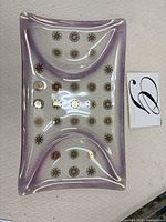 Full view of purple glass tray showing shape and decorative motifs