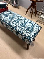 Full view of bench showing upholstery pattern and legs