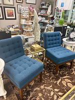 Pair of matching royal blue tufted armless chairs on patterned rug