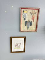 Both framed artworks on wall showing relative sizes