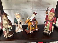 Group shot of four Santa figurines on shelf