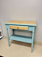 Full front view of the side table showing drawer, legs and shelf