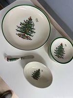 Stack of six cereal bowls with green rim and Christmas tree motif