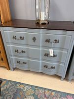 Front view of refinished blue three-drawer dresser with ornate hardware