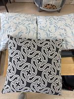 All three pillows displayed together: two blue-white pillows and one black-gray pillow