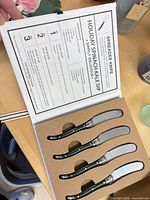 Cheese spreader knife set in open book-style case