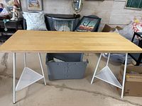 Full front view of desk showing wood top, white metal legs and triangular shelves