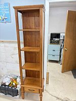 Front view showing entire cabinet, four shelves, faux drawer, legs
