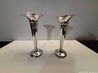 Frontal view of both sterling silver bud vases standing upright