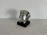 Front view of silver-clad horse head sculpture on black base