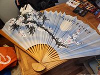 Full view of unfolded decorative fan on table