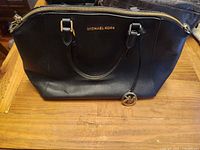 Front view of black Michael Kors leather satchel showing logo, handles and overall condition