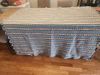 Full view of afghan spread on table showing overall size and stripe pattern
