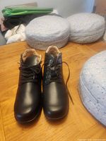 Pair of black orthopedic hiking shoes on table